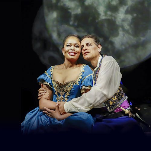 Pretty Yende and Juan Diego Flórez kneeling on stage holding one another