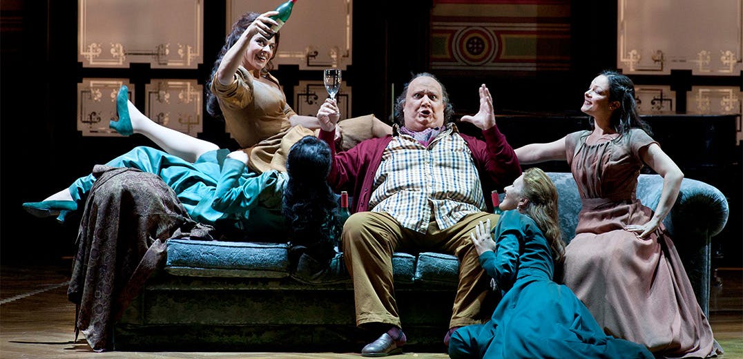 A group of people sitting on a couch and celebrating with wine