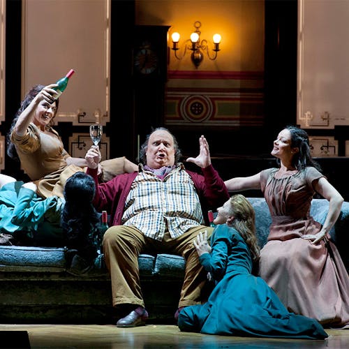A group of people sitting on a couch and celebrating with wine