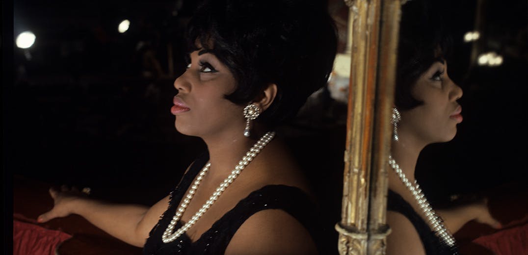 Leontyne Price standing with a mirror behind her
