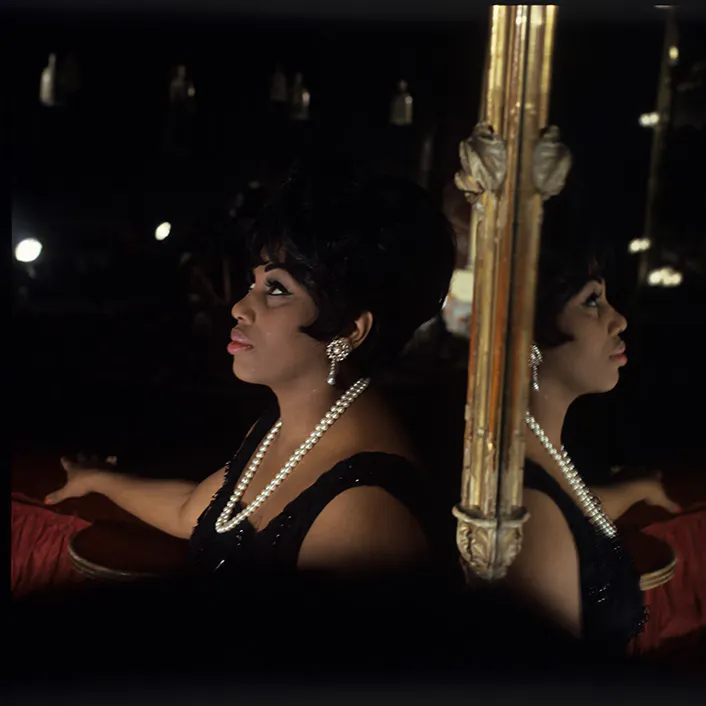 Leontyne Price standing with a mirror behind her