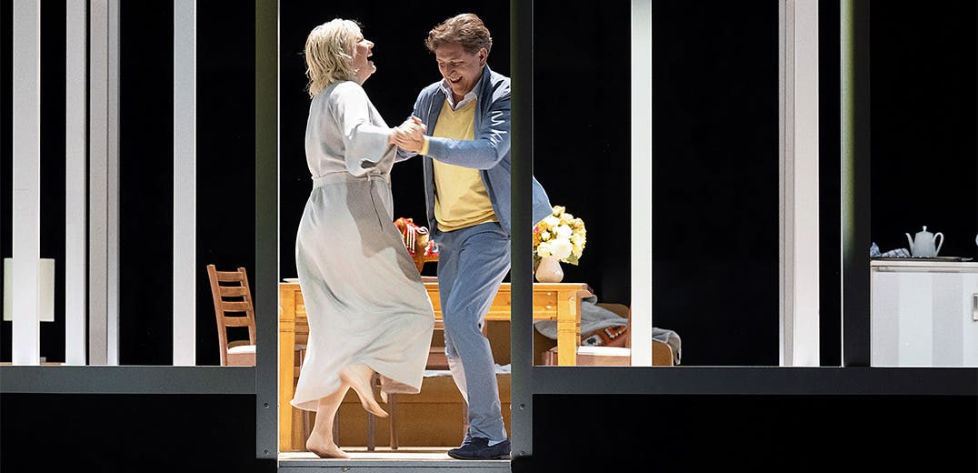 Two people dancing in front of a table