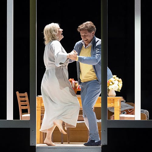 Two people dancing in front of a table