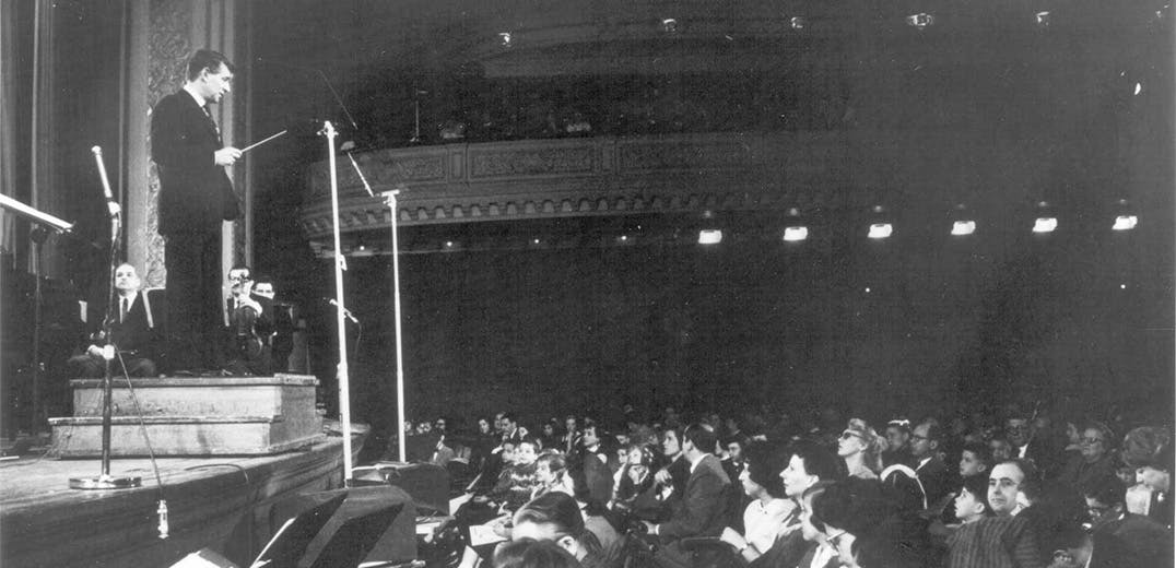 Leonard Bernstein standing at a podium
