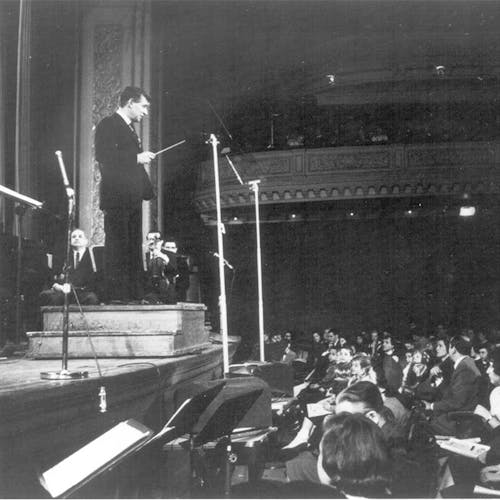 Leonard Bernstein standing at a podium