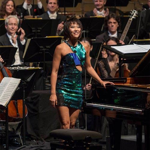 Yuja Wang standing in front of an orchestra