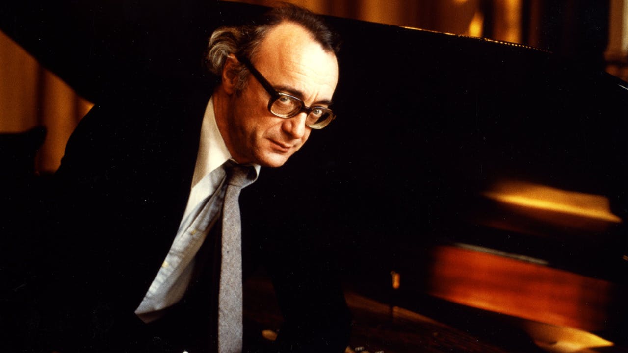 Alfred Brendel sitting in front of a piano