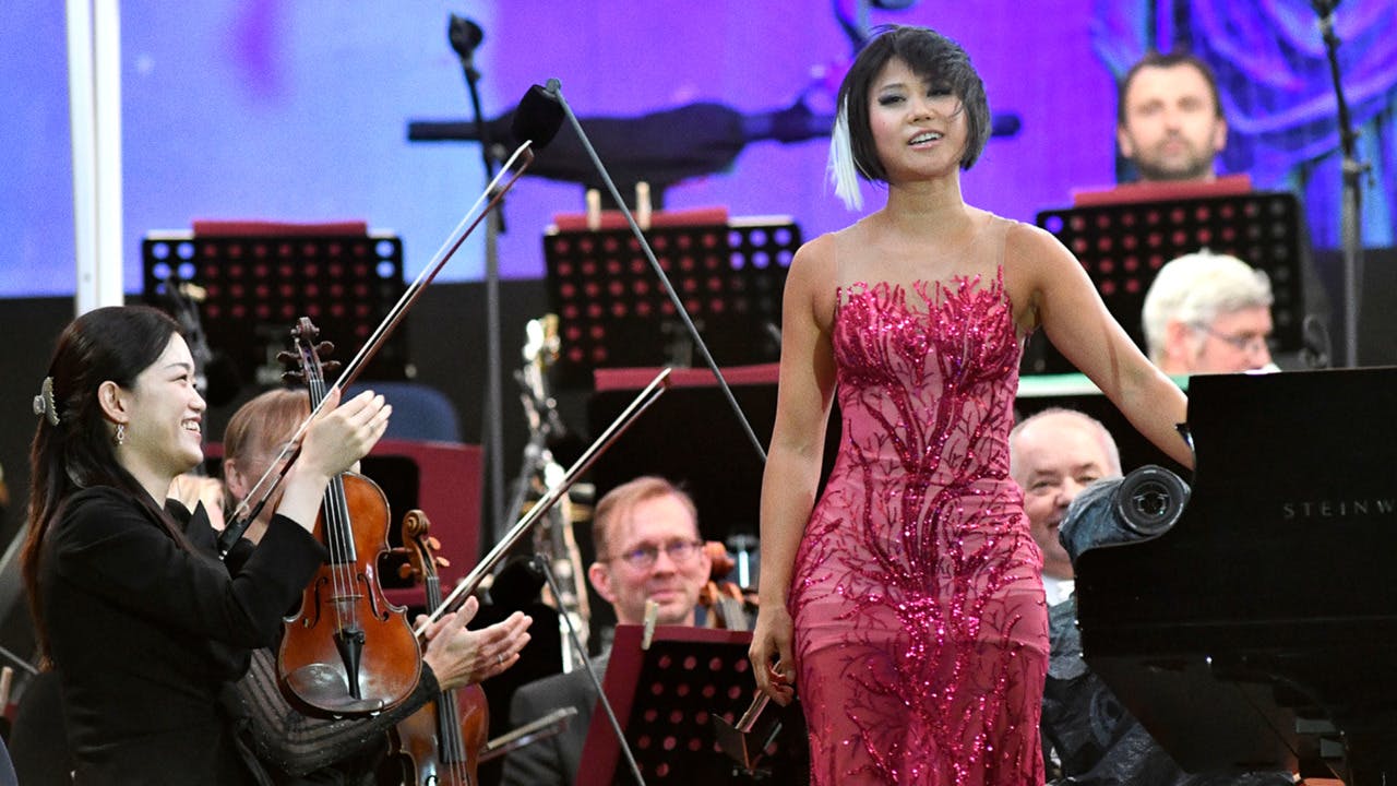 Yuja Wang standing on stage for an applauding orchestra